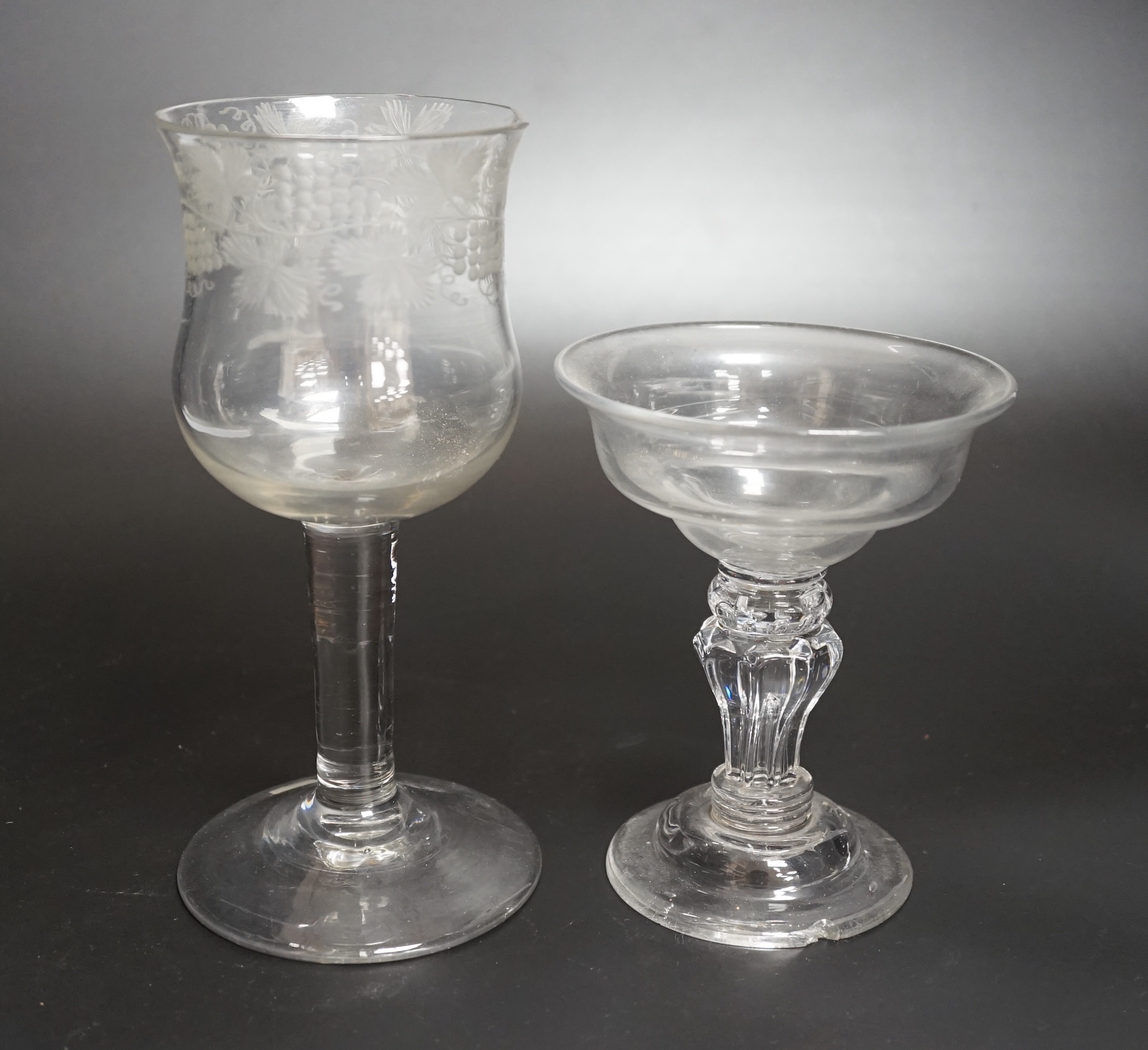 Two champagne or sweetmeat glasses c.1740, with double ogee bowls, the taller example with etched vines around bowl and plain stem, the shorter example with collar under the bowl, over a eight sided moulded pedestal stem